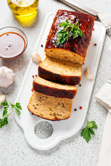 Tasty homemade ground baked chicken meatloaf glazed with barbeque sauce .