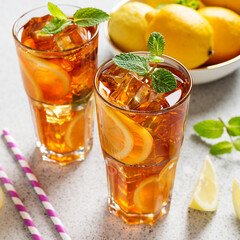 Iced tea with lemon, mint and ice cubes. Iced cold summer drink.	
