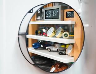 Circle Mirror with reflection of Toys and clocks on a Shelf
