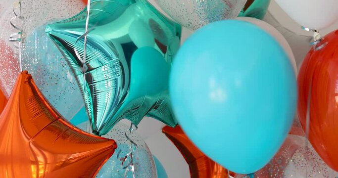 Composition of blue, silver, orange and transparent balloons with helium. Foil balloon in the shape of a star. The concept of decorating a room with helium balloons for holidays or birthdays