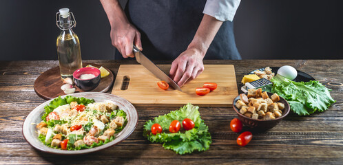 Chef is cutting the tomatoes. Concept of the process of preparing a fresh delicious salad