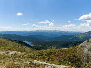 The view from the top of the mountain. Light Lake in the Ergaki Nature Park. Panorama of the distant Siberian mountains