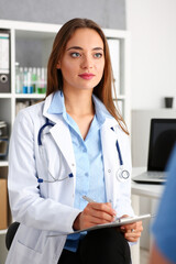 Female doctor hold hold in arm silver pen and pad during ward round check portrait. Medic exam aid visit and remedy prescribe for sick office business visitor with problem and complaint for anamnesis