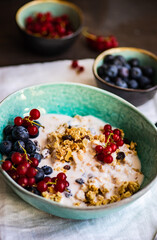 Breakfast food concept with cereals, yogurt and berries on concrete background with copy space
