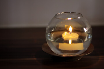 Aromatic candle floating on water in transparent vase