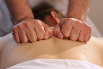 Fototapeta premium Close up of hands with closed fist massaging female back
