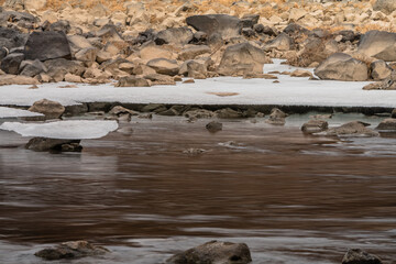 Sheets of ice frozen to large boulders