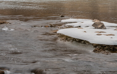 Sheets of ice frozen to large boulders