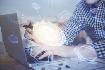 Blockchain theme hologram with man working on computer on background. Concept of crypto chain. Double exposure.