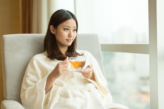 Pretty young girl drinking tea indoors