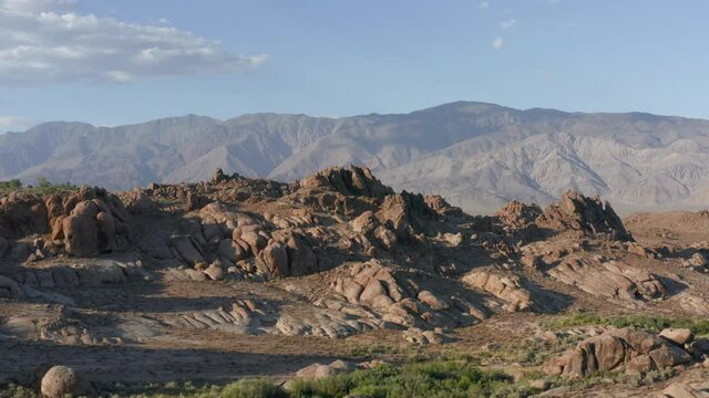 Cinematic California wilderness landscape with beautiful stone park and blue skies above Alabama Hills, USA. 4K aerial slow motion of beautiful rocks at sunset. Outdoor travel, nature adventure, USA