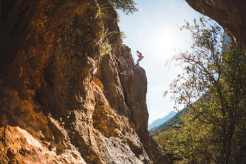 A rock climber descends on a rope after overcoming a climbing route.