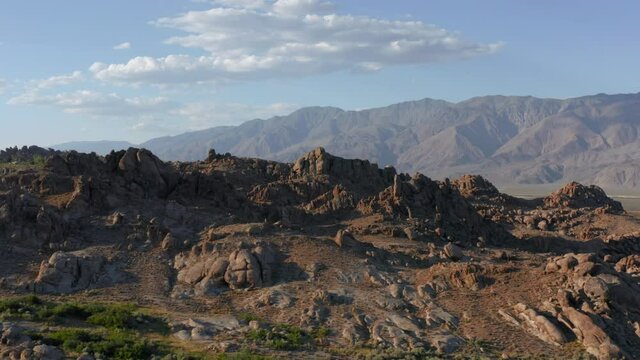 4K aerial slow motion of beautiful rocks at sunset. Outdoor travel, USA. Wild nature adventure. Cinematic California landscape with beautiful stone park and blue skies above Alabama Hills, USA.