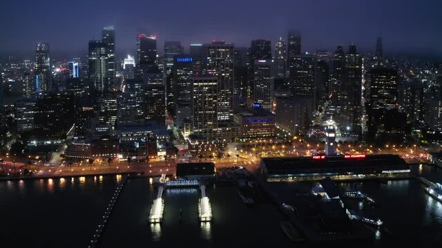 Cinematic aerial panorama of beautiful American city at the bay at night time. Waterfront skyscrapers and streets lights illuminating the night. Beautiful architecture of urban view. 4K San Francisco