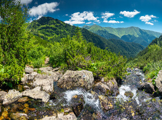 Amazing river waterfall in the heart of the mountains during a sunny day - Romania Fagaras Mountains