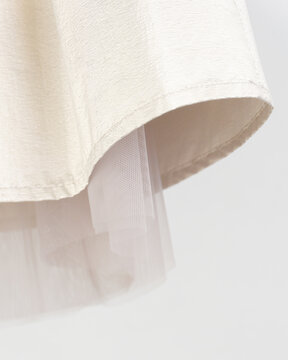 Detail of a golden skirt with a beige petticoat