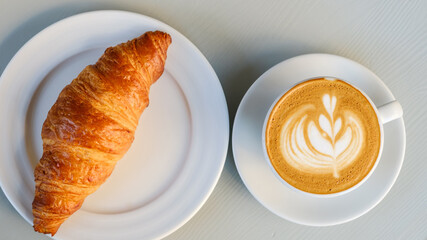 Top view on plates with croissant and latte