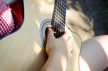 Girl with an acoustic guitar guitar in hand.