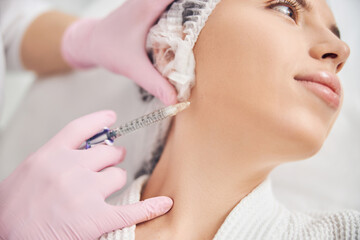 Young woman undergoing cosmetic procedure in salon