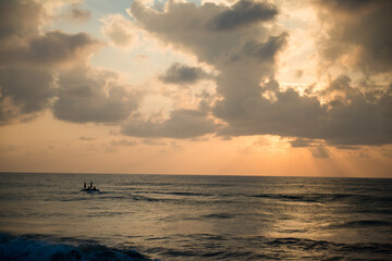 bateau de pêche au lever du jour oranger  sur une mer du sud de l'île de Ceylan, Sri Lanka