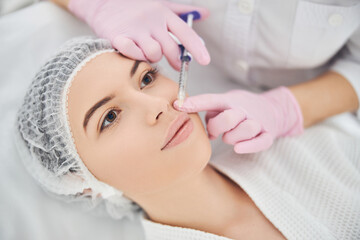 Pretty female patient is receiving injectable therapy