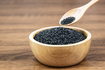Black sesame seeds in a wooden spoon For healthy food and diet concepts.