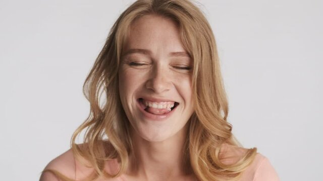 Portrait of pretty blond girl happily blowing bubblegum isolated. Face expression