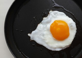 yummy fried egg on a black surface . food close up.