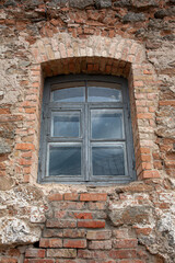 
Fragment of an old brick (stone) wall with a window in a wooden frame