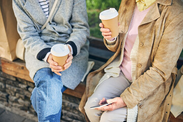 Good looking women sitting on the bench and talking about good weather
