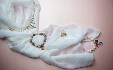 Fashion accessory necklace,bracelet,earrings with swarovski crystal stones isolated on pink background