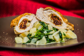 Chicken breast stuffed with cheese and roasted beef meat with potatoes on brown plate. The food in the restaurant. Food styling and restaurant meal serving.