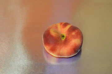 ripe fig peach close-up with reflection on shiny metallic silver gray background