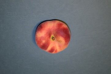 peach nectarine top view - exotic fruit on an embossed blue-green background