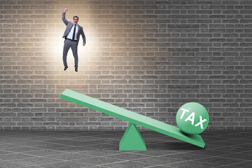 Businessman in tax concept with seesaw
