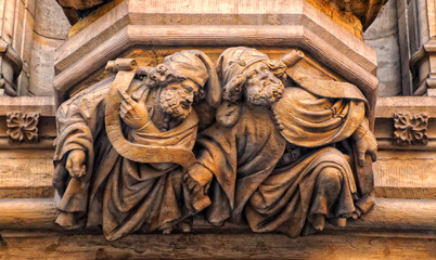 Bas relief decoration sculptures of two man at Town Hall facade in Brussels, Belgium.