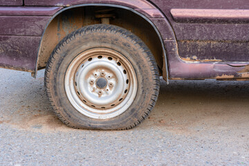 Damaged tire. The wheel of car tire leak. Flat tire waiting for repair. Abandoned car in the parking lot.