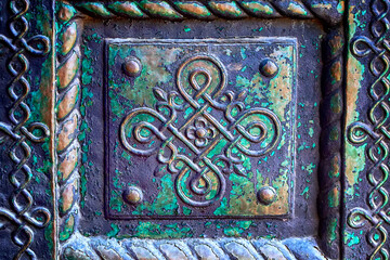 Traditional ornamental decoration at metal entrance door in the church.