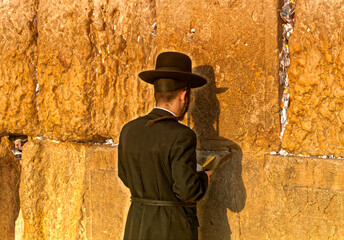 Jewish male in traditional clothes in afternoon prayer at Wailing Wall in Jerusalem, Israel.
