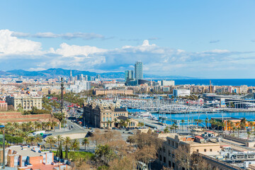 Cityscape of the port and part of the city of Barcelona, ​​wonderful sunny day with a blue sky and white clouds in Spain
