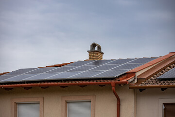 Photovoltaic or solar panels on roof at overcast sky.
