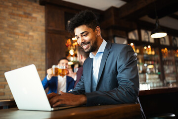 Portrait of a successful business man sitting at the cafe working on a laptop.