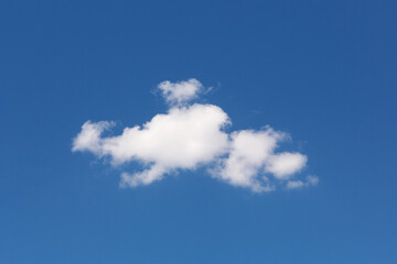 one white cloud of a bizarre shape, against a blue sky