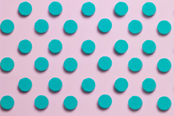 Numerous round and green tiles create a lines pattern on a pastel-colored background.