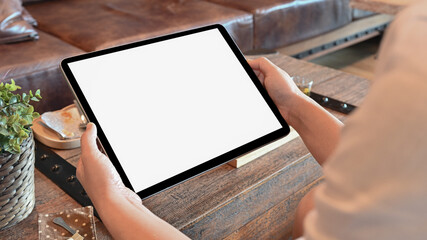 Mockup of Woman holding the tablet in the cafe.