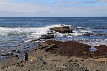 A Father cuddling his son after having fun exploring the rock pools on the seashore at Spanish Point, County Clare, Ireland.