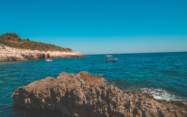 Panoramic afternoon view of beautiful rocky Cliffs with people on boats in Kamenjak National Park, Istria, Croatia