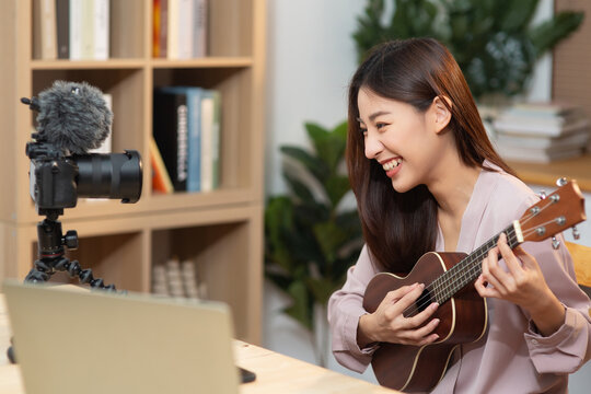 Young influences woman playing and teaching guitar while record by filming on camera