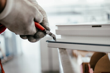 Manual worker assembling PVC doors and windows. Manufacturing jobs. Selective focus. Factory for aluminum and PVC windows and doors production.