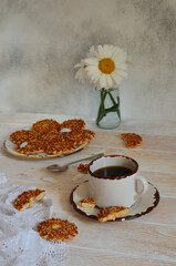 Daisies, homemade cookies, and a cup of coffee on the wooden table. Nice breakfast lifestyle at home